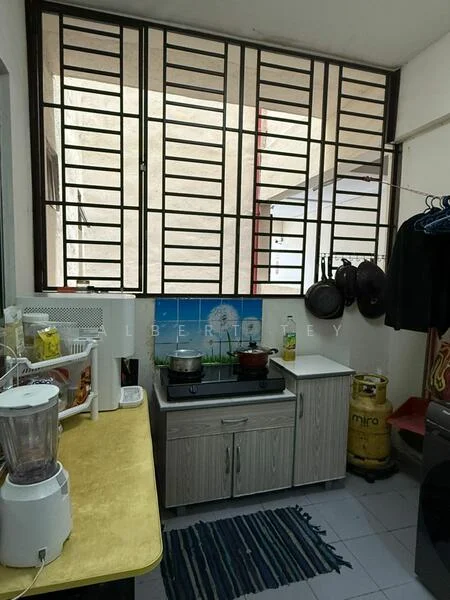 Kitchen features: yellow countertop, stainless-steel gas stove, wooden cabinetry, blender, kettle, cooking pots hanging on wall, white tiled flooring, window with metal grille, blue and green wall mural, refrigerator, striped area rug.