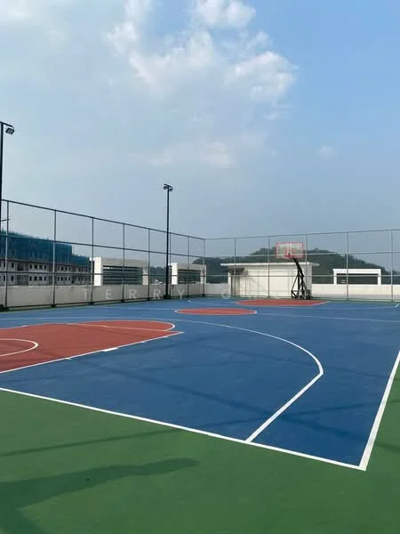 Exterior type: basketball court; features: multi-colored court surface, basketball hoop, surrounding fencing, outdoor lighting poles, green perimeter, blue and red court markings, open sky view; style: modern.