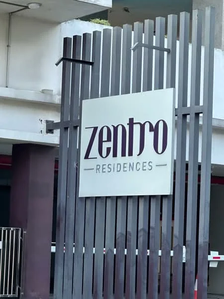 Exterior features: signage with the name 'zentro RESIDENCES', wooden slat design, modern architectural elements, concrete structure, surrounding greenery; style: modern.