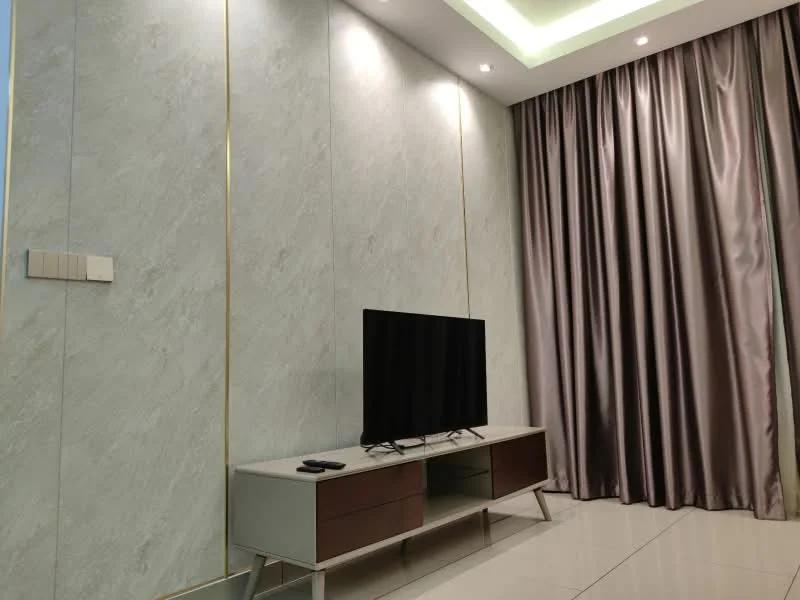 Living features: light grey marble wall with gold trim, floor-to-ceiling curtains in light grey, recessed ceiling lights, LED strip lighting in ceiling, flat-screen TV on low-profile media console, white media console with wooden drawers, polished tile flooring, remote control on the floor; style: modern.