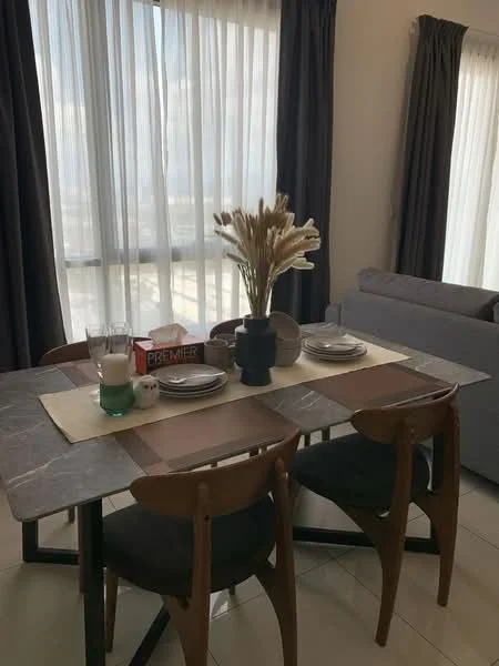 Dining features: marble dining table, 4 wooden dining chairs, table runner, decorative vase with dried flowers, set of plates, glass of water, table placemat, window with sheer curtains, grey upholstered sofa in background, floor-to-ceiling windows, natural light, neutral wall color, tile flooring; style: modern; view: city.