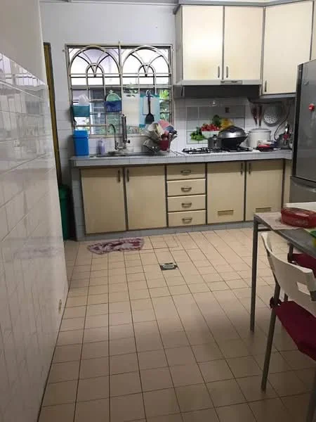 Kitchen features: light wood cabinetry with gold handles, grey countertop, stainless-steel sink, chrome faucet, gas stove with oven, white tiled backsplash, refrigerator, floor tiles in beige, window with decorative grille, kitchen table with white chairs, various kitchen utensils and appliances visible, green trash bin.