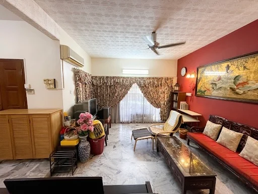 Living features: marble flooring, red accent wall, cream painted walls, 5-blade ceiling fan, large window with sheer curtains, wooden coffee table, 3-seater sofa with red upholstery, wooden side table, decorative wall clock, framed artwork, floor lamp, wooden shelving unit, reclining lounge chair, potted plants; style: traditional.