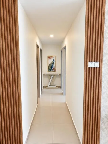 Hallway features: white painted walls, beige ceramic tile flooring, smooth white ceiling, recessed downlight, narrow corridor layout, wood slat wall cladding, light switch panel, doorway openings on both sides, console table, framed artwork, neutral trim; style: modern.