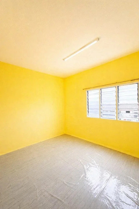 Room features: yellow painted walls, vinyl flooring, sliding windows, ceiling light fixture.