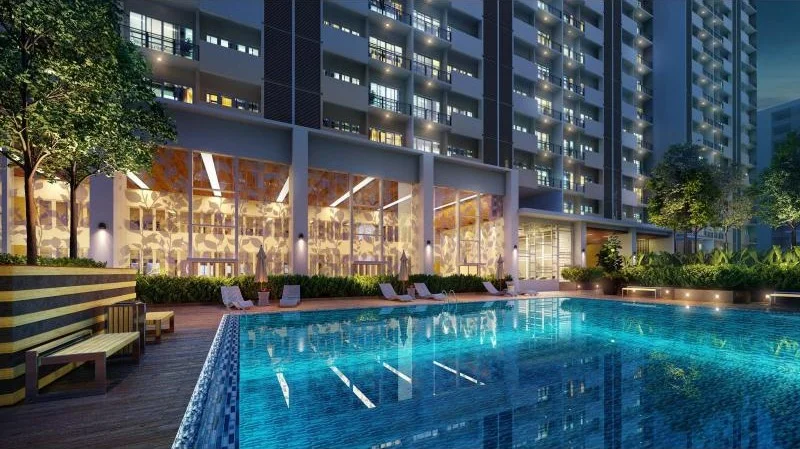 Exterior type: high-rise condominium; features: infinity pool, pool deck with loungers, landscaped garden, glass curtain wall facade, illuminated building at night, surrounded by greenery, outdoor seating area, decorative lighting; style: modern.