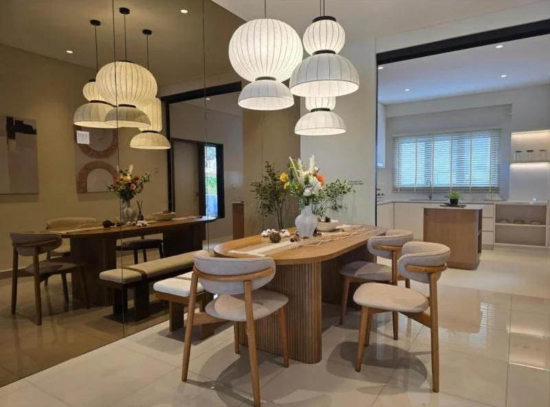Dining features: 6-seater dining table, upholstered dining chairs, wood dining table, pendant lights, large wall mirror, white painted walls, glossy large-format tile flooring, recessed ceiling downlights, decorative floral arrangement, bench seating, open-plan layout, neutral beige and wood colour scheme; style: modern. Kitchen features: white painted walls, glossy large-format tile flooring, recessed ceiling downlights, window with white venetian blinds, white countertop, wood-front kitchen island, built-in cabinetry, open shelving, stainless-steel sink, chrome faucet, under-cabinet lighting, open-plan connection to dining area; style: modern.