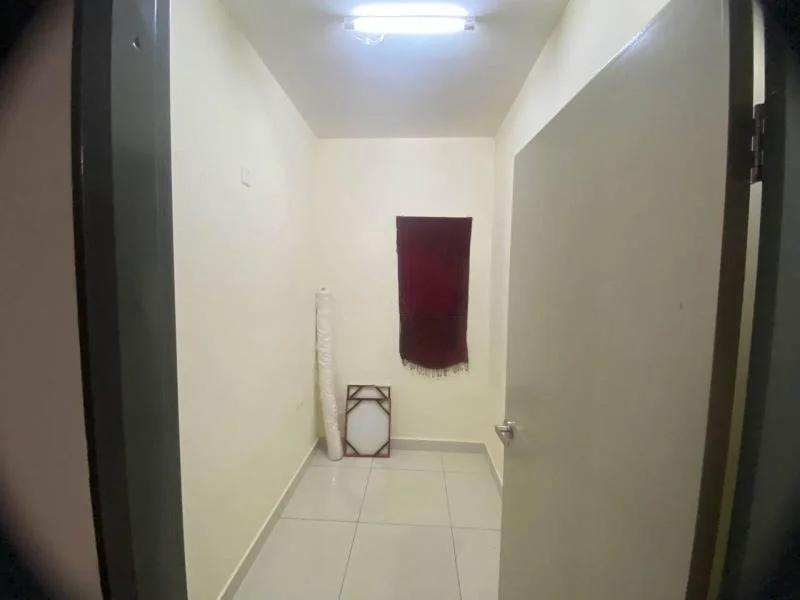 Room features: white painted walls, tile flooring, ceiling light, single door, window with red curtain, rolled-up carpet, framed object on the floor.