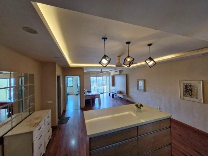 Living features: wooden flooring, recessed ceiling with LED strip lighting, 3 pendant lights, large windows with city view, open layout, wall-mounted mirror, neutral wall color, decorative wall art; style: modern; view: city. Kitchen features: kitchen island with countertop, stainless-steel sink, built-in cabinetry, open shelving; style: modern.