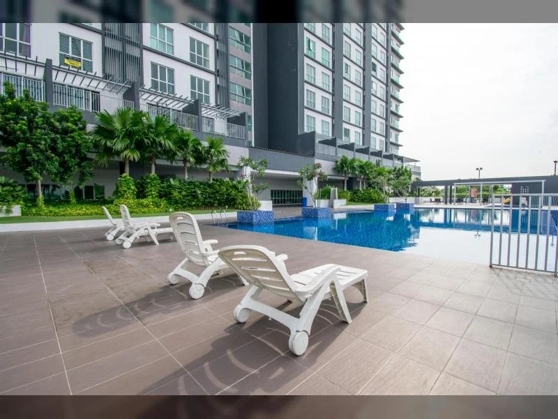 Exterior type: high-rise condominium; features: infinity pool, pool deck with loungers, landscaped garden with palm trees, tiled flooring around pool area, glass railing, modern architectural design, multiple storeys visible, surrounded by greenery; style: modern.