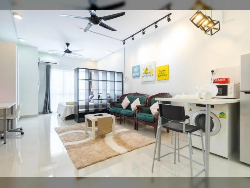 Living features: white painted walls, glossy tile flooring, 5-blade ceiling fan with light, recessed downlights, sofa in green upholstery, coffee table, area rug with geometric pattern, TV console, wall-mounted TV, open shelving unit, dining table for 4, washing machine, microwave, decorative wall art; style: modern.