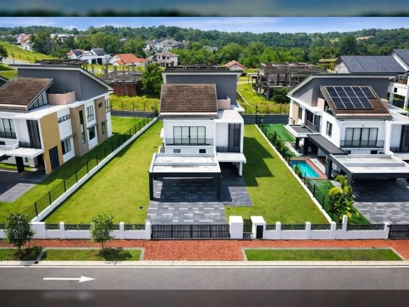 Exterior type: detached bungalow; features: double-storey, white and grey facade, pitched tile roof, flat roof car porch canopy, large front lawn, black metal perimeter fence, gated entry, driveway with interlocking pavers, covered car porch, solar panels on roof, balcony with glass railing, sliding glass doors, surrounded by mature greenery, fronts a quiet residential street; style: modern.