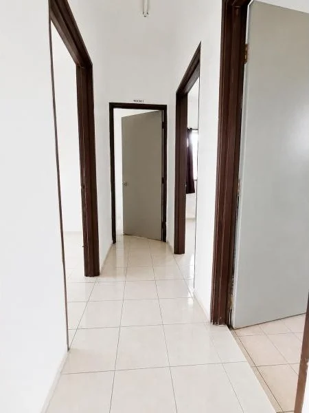 Hallway features: white painted walls, cream ceramic tile flooring, dark wood door frames, multiple interior doorways, plain white ceiling, recessed ceiling light point, narrow corridor layout, light grey painted doors, glossy tiled floor finish, simple residential interior; style: contemporary.
