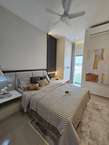 Bedroom features: king-size bed with beige bedding, upholstered headboard, bedside table with lamp, ceiling fan, wall-mounted air conditioning unit, large window with sheer curtains, decorative wall art, area rug with geometric pattern, built-in wardrobe, neutral painted walls, polished tile flooring; style: modern; view: garden.
