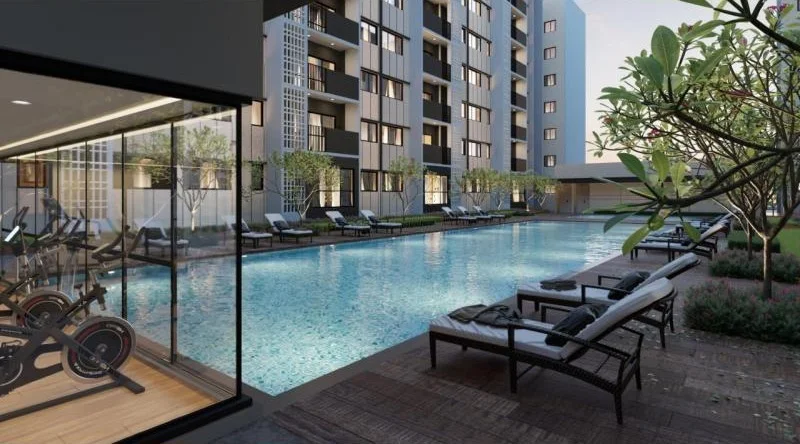 Exterior type: high-rise condominium; features: infinity pool, pool deck with loungers, gym with glass walls, landscaped garden, mature trees, tiled pool area, modern architecture, multiple storeys, balconies on upper floors; style: modern.