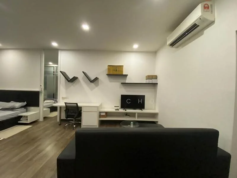 Living features: dark fabric sofa, wooden flooring, white painted walls, recessed LED downlights, wall-mounted air conditioning unit, built-in shelving units, desk with chair, TV console, glass coffee table; style: modern. Room features: grey bedding, glass door leading to another room.