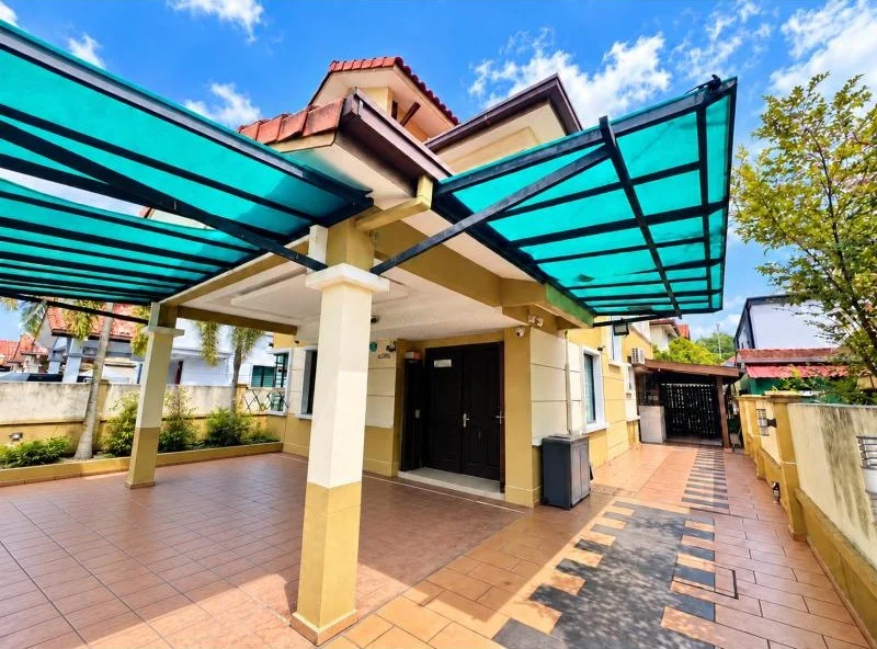 Exterior type: detached bungalow; features: double-storey, cream painted facade, red tiled pitched roof, projecting car porch canopy, turquoise translucent polycarbonate awning, covered car porch, driveway with terracotta tiles, stone-paved walkway, gated side entrance, perimeter wall, fronts a quiet residential street, surrounded by mature greenery; style: traditional.