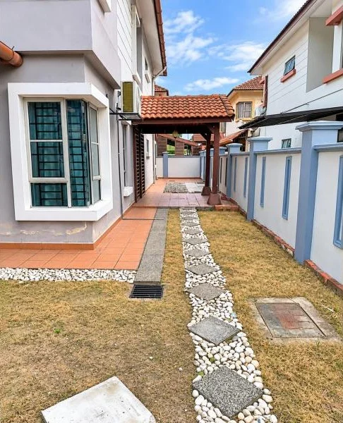 Exterior type: semi-detached house; features: double-storey, white painted facade, light grey exterior walls, projecting bay window, terracotta tiled roof, covered side walkway, tiled patio area, stone-paved stepping path, small lawn area, boundary wall with blue trim, covered car porch, metal awning, drainage grates, fronts a quiet residential street; style: contemporary.