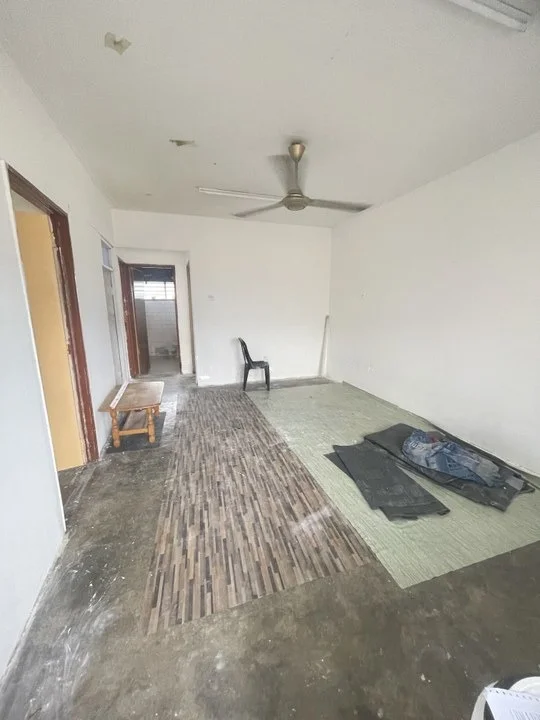 Room features: white painted walls, concrete flooring, 5-blade ceiling fan, single wooden bench, black plastic chair, area rug with bamboo pattern, exposed ceiling, unfinished flooring materials; style: minimalist.