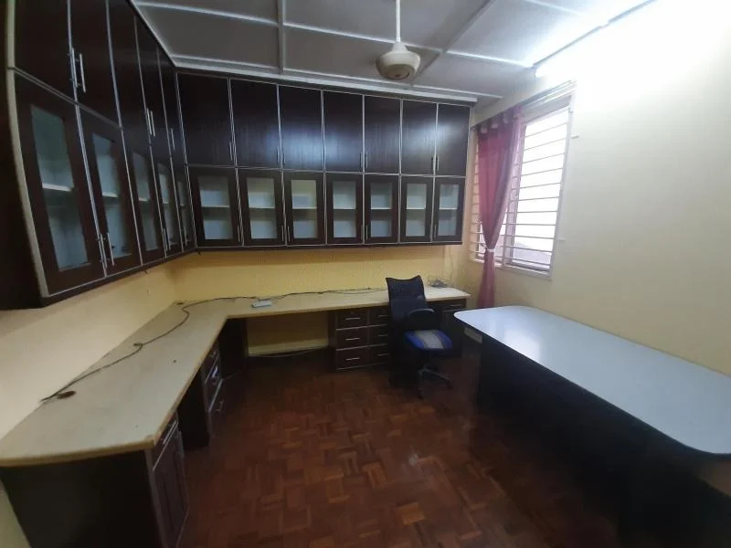 Study features: wooden flooring, built-in wooden cabinetry with glass-fronted doors, L-shaped desk, additional desk with rounded edge, ceiling fan, window with horizontal slats, curtains in red fabric, yellow painted walls, power outlets visible, task chair in blue fabric; style: modern.