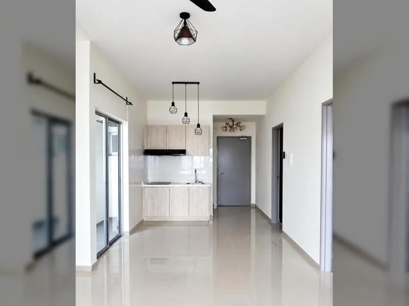 Kitchen features: white painted walls, glossy beige floor tiles, white ceiling, recessed ceiling bulkhead, sliding glass door, black curtain rod, light wood flat-panel cabinets, white backsplash tiles, stainless-steel sink, chrome faucet, black range hood, compact kitchenette, pendant lights, black geometric ceiling light, wall-mounted split AC, grey front door, hallway opening, white baseboards; style: modern.