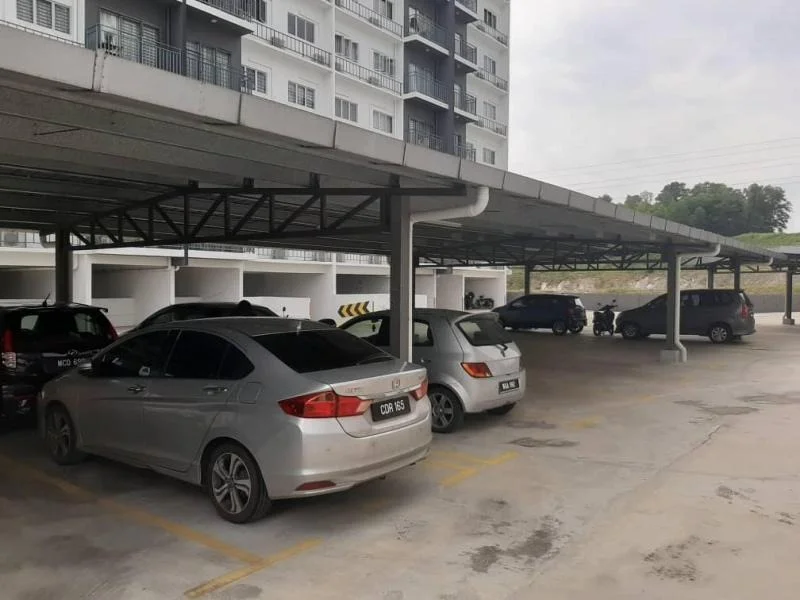 Exterior type: multi-storey car park; features: covered parking, concrete flooring, metal roof structure, marked parking spaces, surrounding greenery, multiple vehicles parked; style: modern.