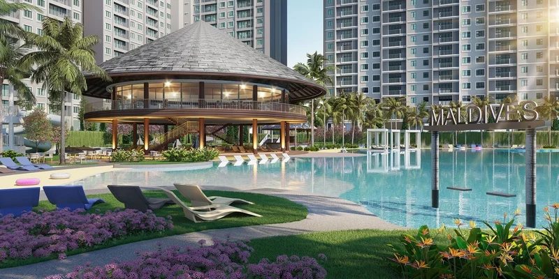 Exterior type: clubhouse; features: swimming pool with loungers, infinity edge pool, landscaped garden with tropical plants, palm trees, outdoor dining area, playground swings, circular clubhouse with thatched roof, manicured lawn, stone-paved walkway, deck chairs, poolside cabanas; style: tropical-modern.