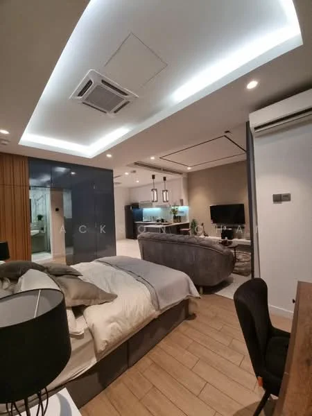 Bedroom features: king-size bed with grey bedding, upholstered headboard, 2 bedside lamps, wooden flooring, recessed ceiling lights, ceiling-mounted air conditioning unit, wall-mounted TV, grey fabric sofa, decorative wall paneling, study desk with chair, open shelving unit, glass partition wall, decorative plants; style: modern.
