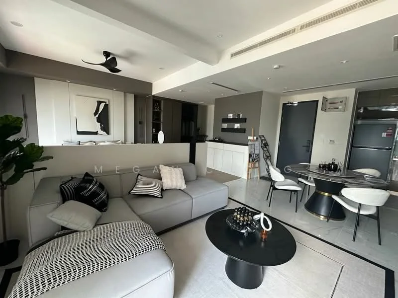 Living features: 3-seater fabric sofa in grey, black and white patterned throw pillows, round coffee table with black surface, ceiling fan, wall-mounted TV, decorative wall mirror, open shelving unit, light-colored walls, recessed downlights, area rug with geometric pattern; style: modern. Dining features: 4-seater round dining table, black dining chairs, white cabinetry in background, kitchen island with bar seating, stainless-steel fridge visible, open-plan layout; style: modern.