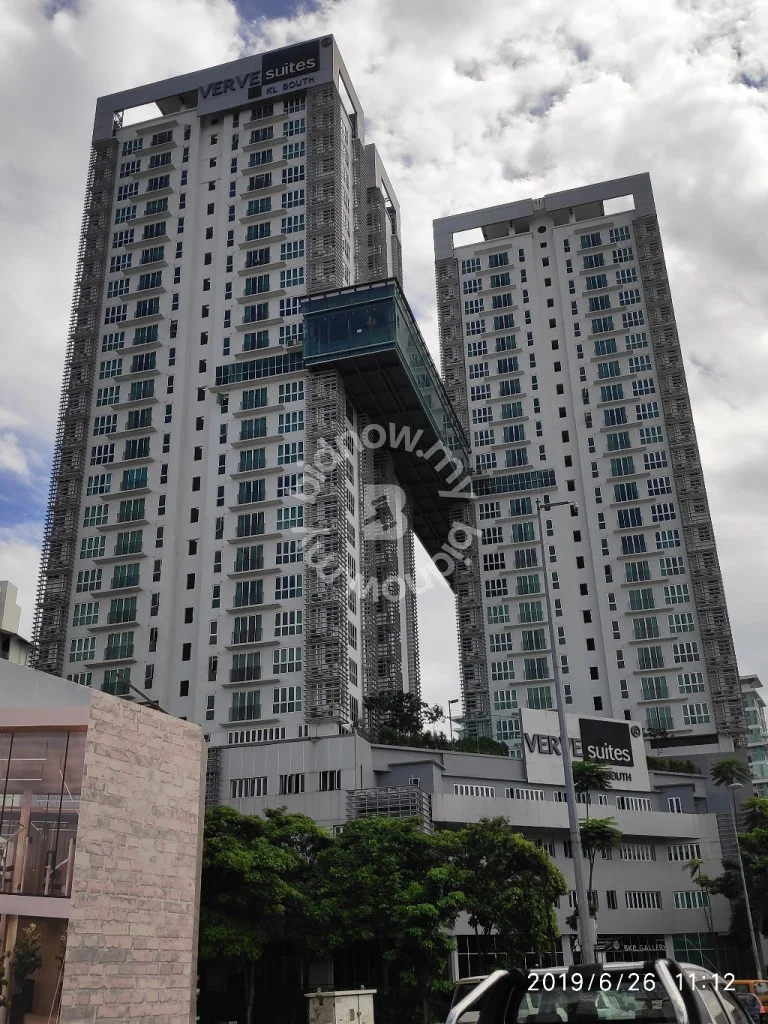 Exterior type: high-rise condominium; features: glass curtain wall, white painted facade, recessed balconies, connecting bridge between towers, multiple storeys, landscaped greenery at base, signage visible, urban context with surrounding trees; style: modern.